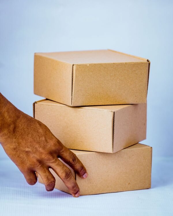 Pack Hub Kraft (Brown) Mailing Boxes Stacked with Hand in Front